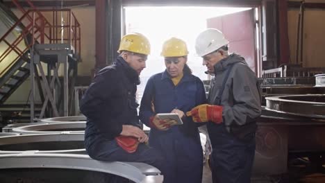 ingenieros discutiendo el proyecto en la instalación de fabricación de metales