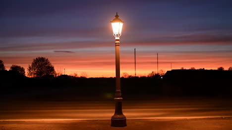 lamppost illuminated against a vibrant sunset sky