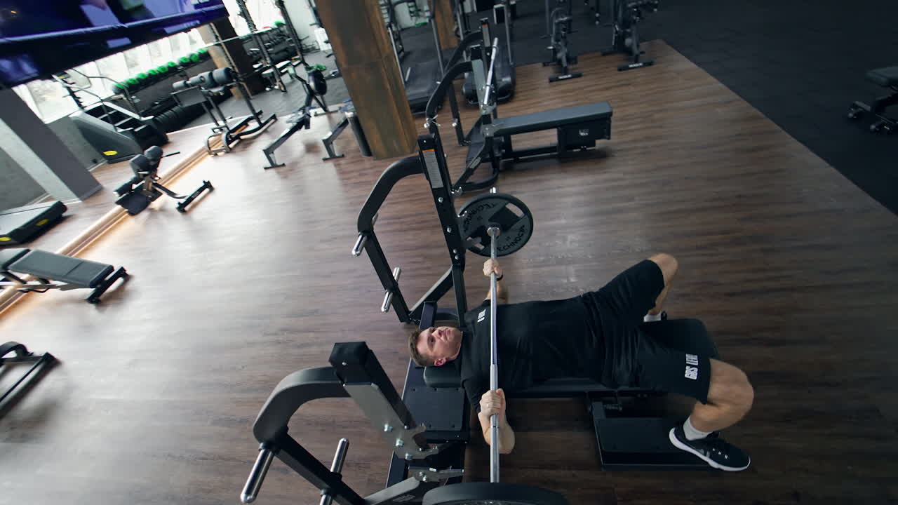 Man performing bench press exercise in a gym