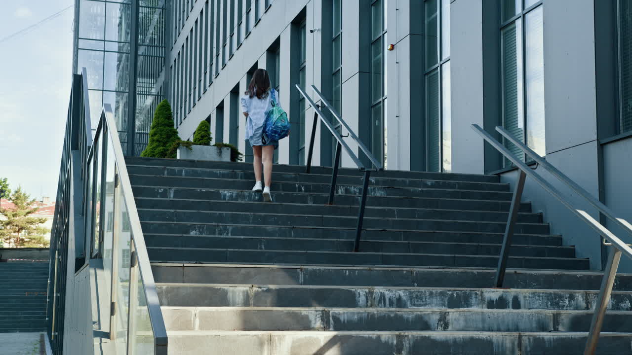 Student walking up stairs at office building