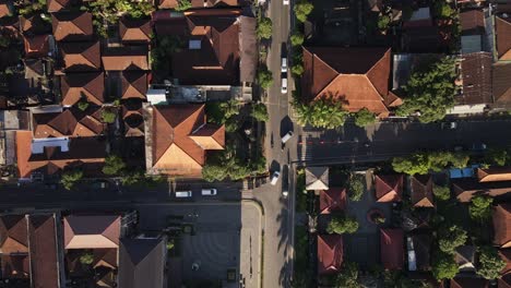 Top-down-aerial-sunrise-view-at-Ubud-downtown-road-surrounded-by-souvenir-shops,-cultural-landmarks-and-traditional-Balinese-buildings,-Bali,-Indonesia