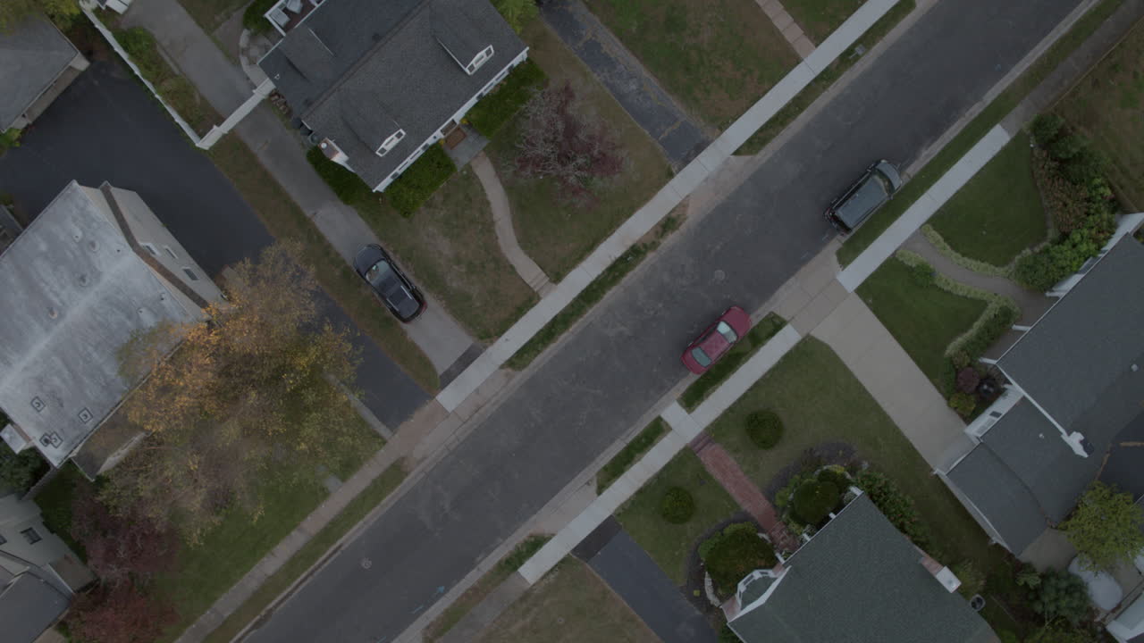 la vista aérea recta hacia abajo de una calle suburbana y la cámara de casas se eleva lentamente