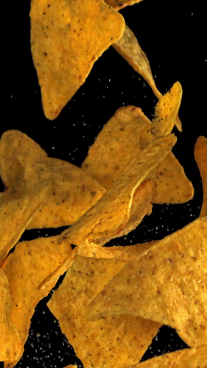 Tortilla chips che cadono al rallentatore su sfondo nero