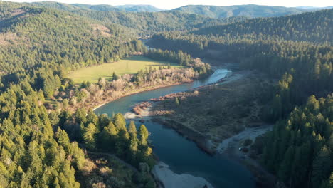 Aguas-Del-Río-Smith-En-El-Parque-Estatal-Jedediah-Smith-Redwoods-Rodeado-De-Bosque-En-Ambos-Lados---Toma-Aérea-De-Drones