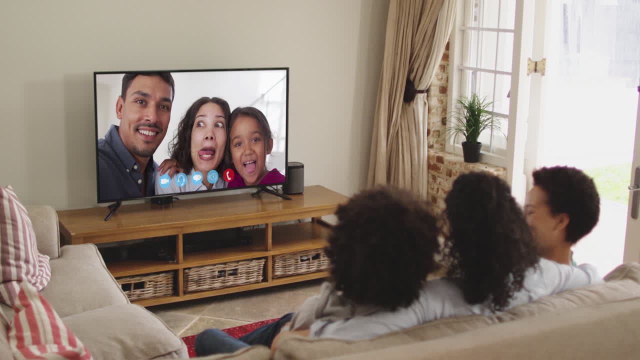 아프리카계 미국인 가족 이 집 에서 소파 에 앉아 tv 에서 비디오 통화 를 하고 있다