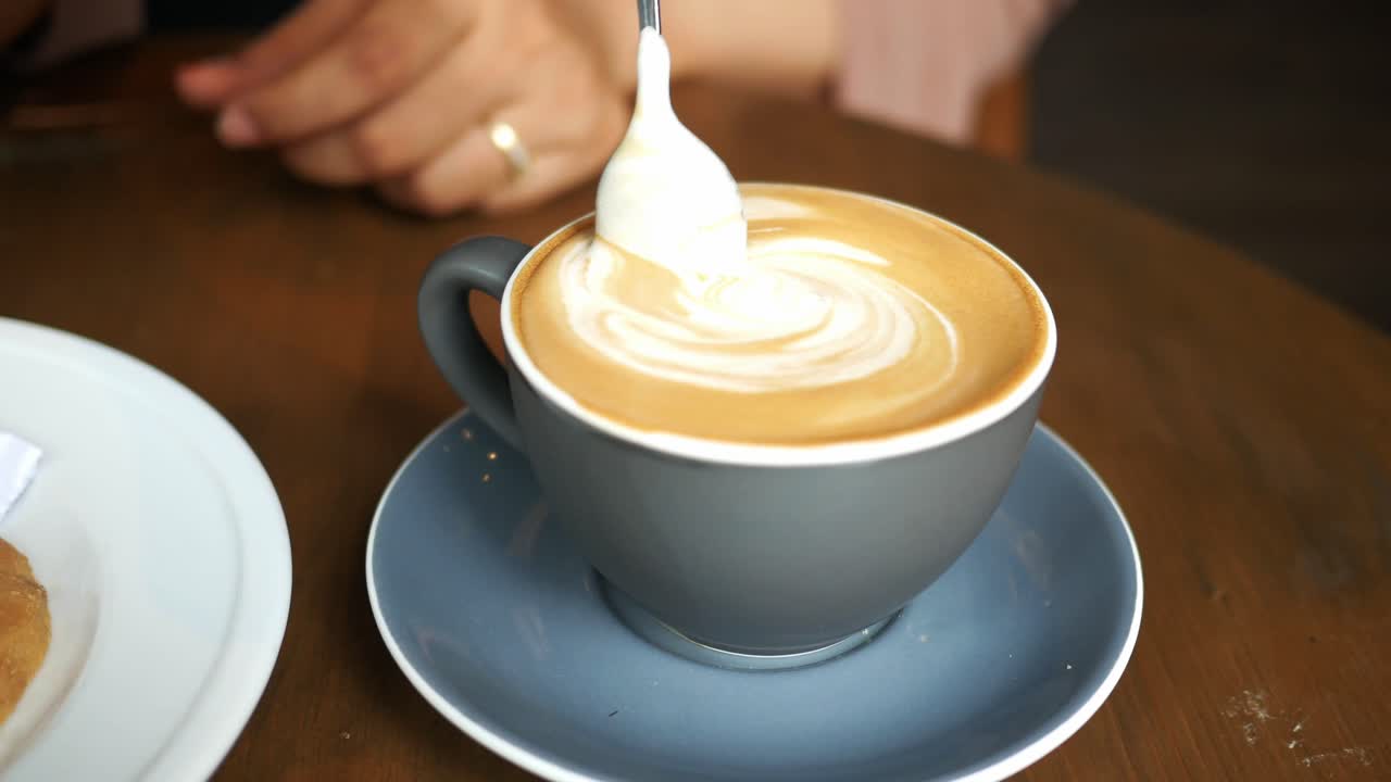 Woman enjoying a cappuccino at a cafe