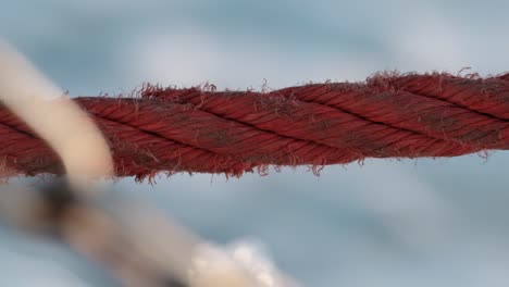 rood touw van een zeilschip met zeegolven die op de achtergrond spetteren