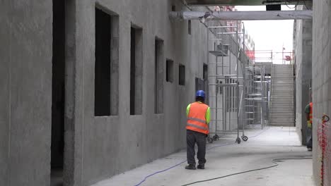 un constructor de construcción enrollando una manguera