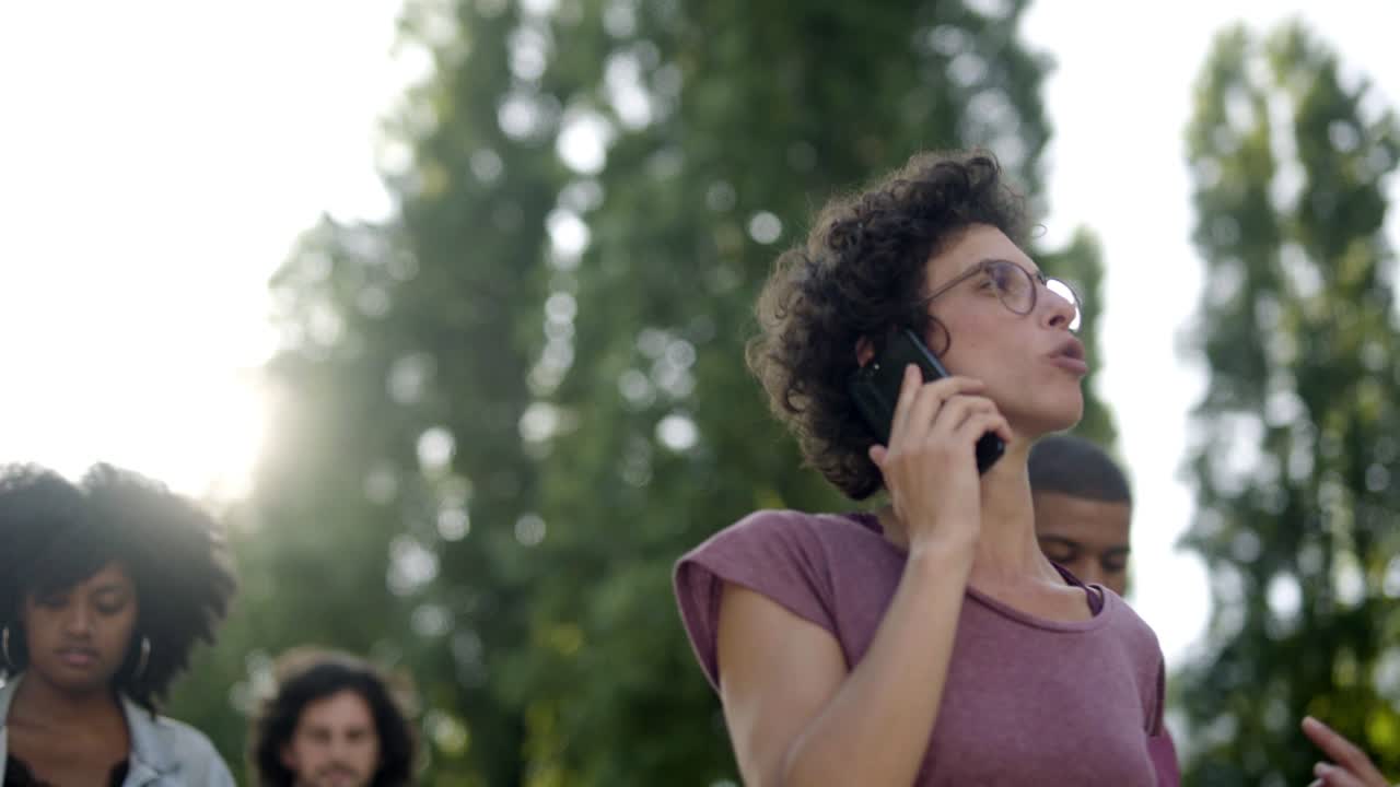mujer joven seria con gafas hablando en el teléfono inteligente