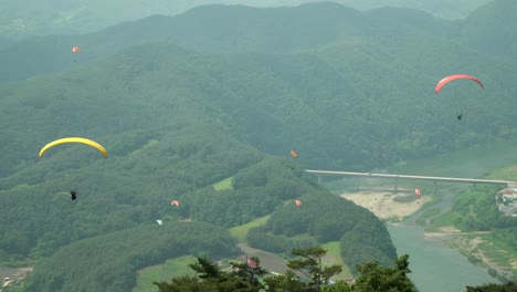 Personas-En-Parapente-En-Tándem-Sobre-Montañas-En-Danyang-Corea-Del-Sur-Vista-Superior