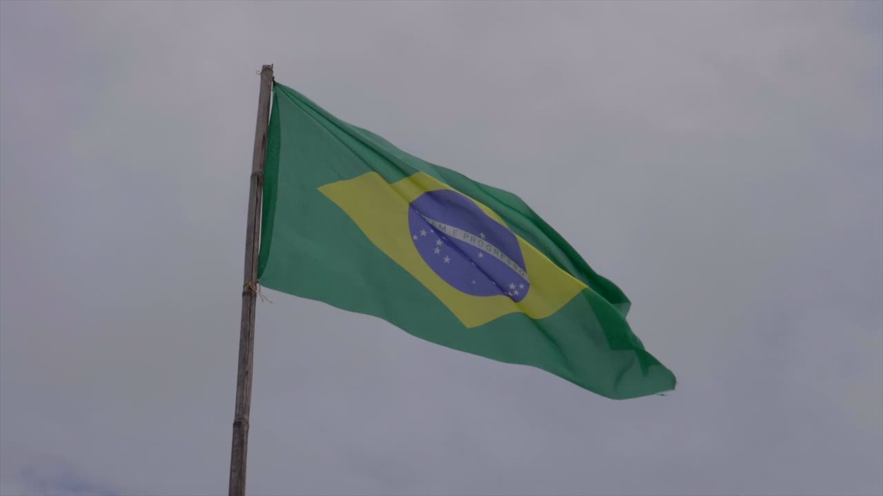 Slowmotion af brasiliansk grønt flag, der blidt blafrer i vinden på overskyet himmel