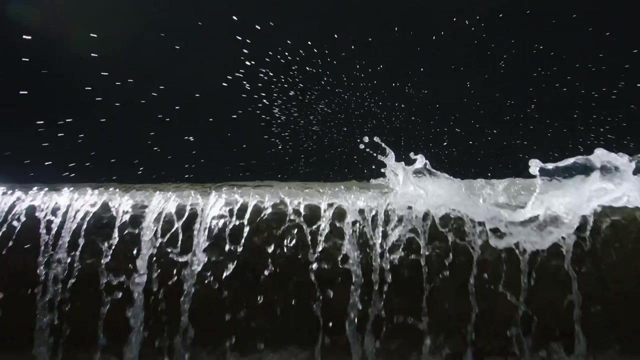 Toont een dunne waterfilm die golft na een gelokaliseerde golf die zich vormt op een pijp in de studio, sproeinevel producerend.