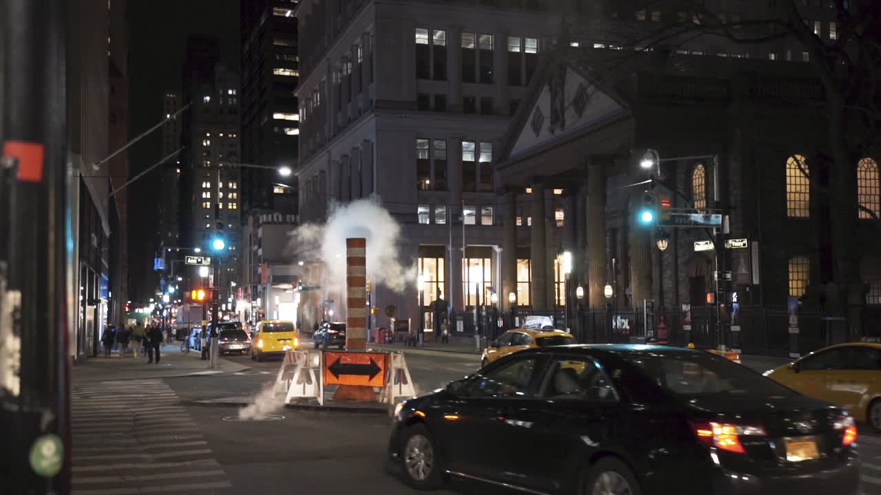 Steam over city street. new york city scene at night. traffic cars lights. New York City. Cars driving through sewage steam after heavy rain, New York City