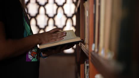 a man browsing ancient books inside al qaraouiyine library in fez