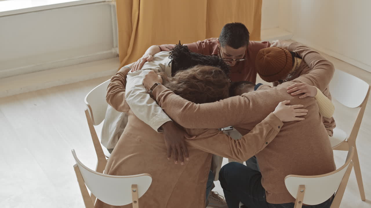 Diverse Group Hugging in Support Group