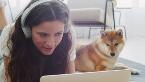 young woman working on her laptop at home next to her dog 5