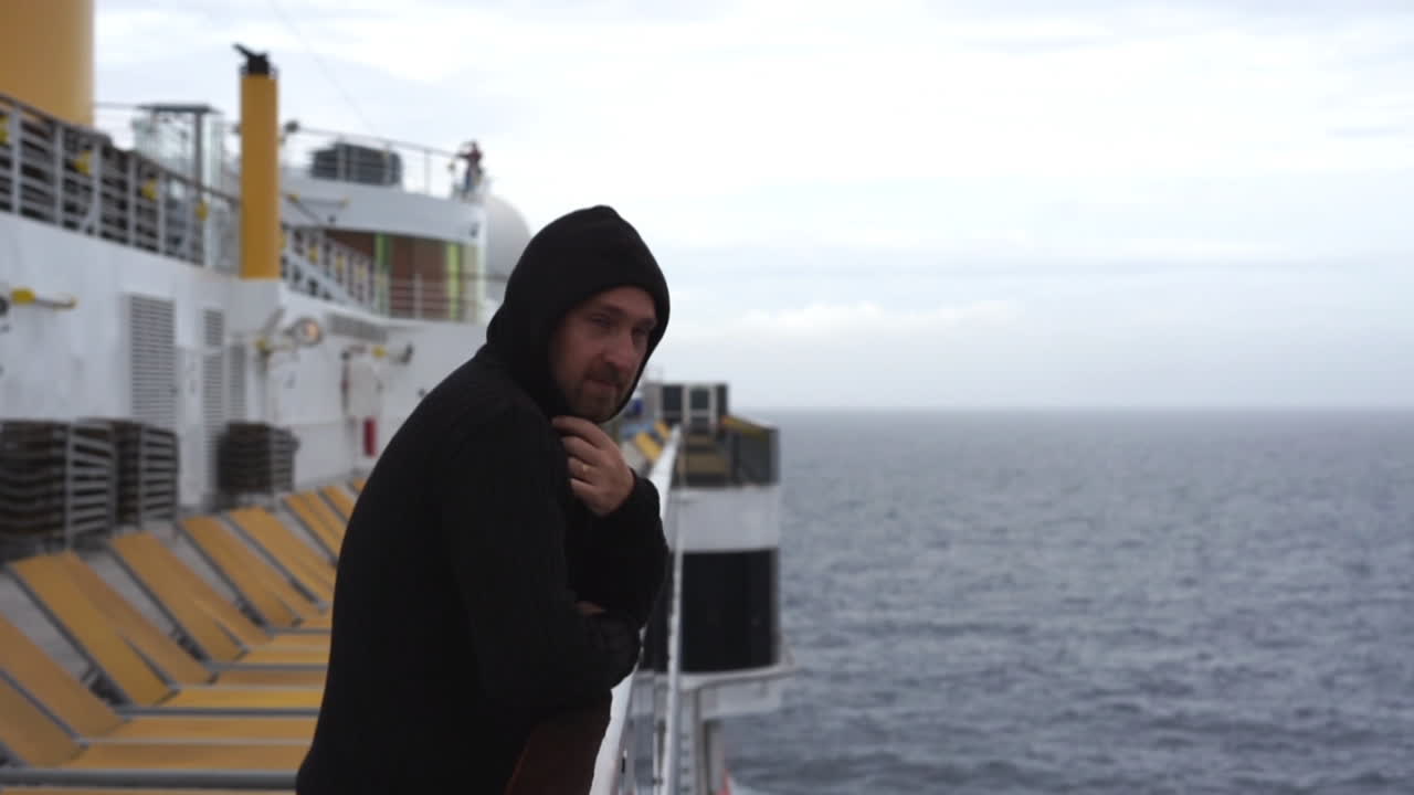 男はクルーズ船の甲板に立ち、笑顔