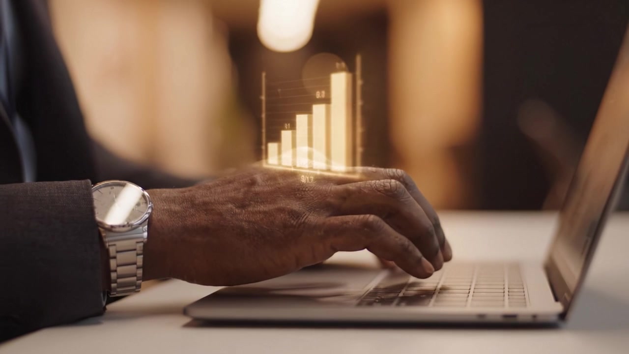 En professionel bruger en bærbar computer til at analysere vækstdata med grafer og nøgletal vist, hvilket illustrerer forretningsstrategi og produktivitet på den moderne arbejdsplads