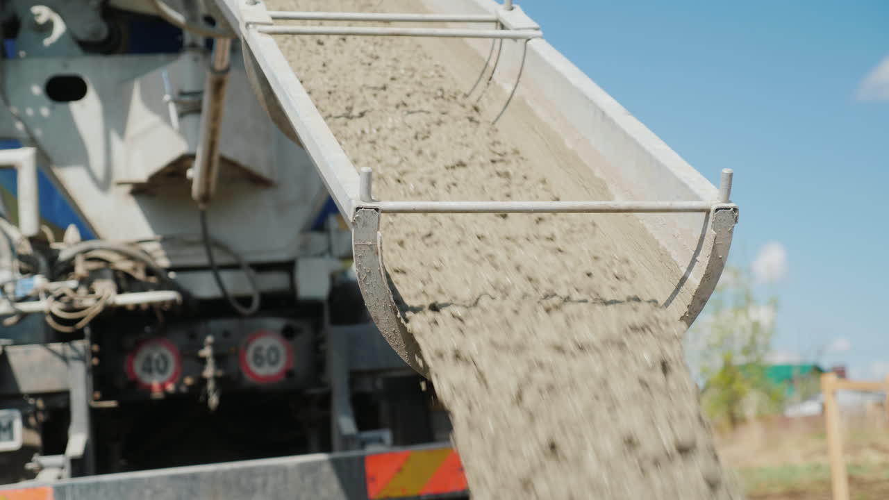 작업자가 콘크리트가 흐르는 낙하산을 지시하는 기초를 붓는 작업