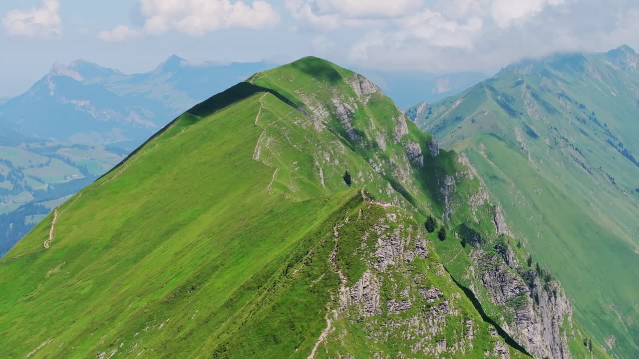 Expansive alpine ridges and lush green peaks along a picturesque mountain trail