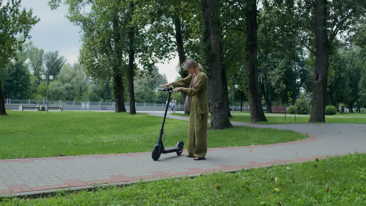 Woman with Electric Scooter in Park