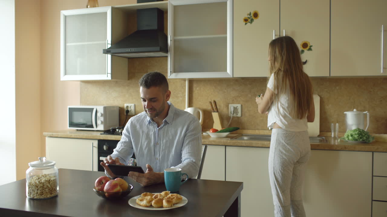 Casal aproveitando o café da manhã na cozinha
