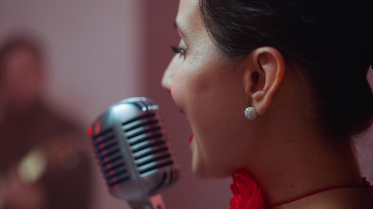 una cantante femenina es capturada cantando alegremente desde el ángulo correcto con un micrófono vintage en foco y un fondo borroso