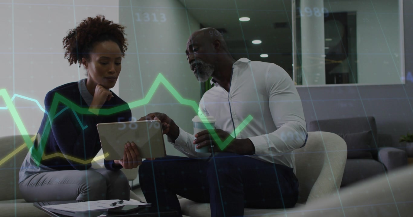 Woman holding tablet to man, tapping, pointing and reviewing finance charts with green or yellow lin