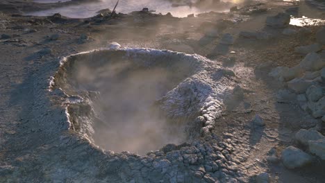 fumarole and mud pools vents out steam fog in reykjanes peninsula, iceland