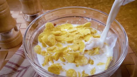 Crispy-yellow-corn-flakes-into-the-bowl-for-the-morning-a-delicious-Breakfast-with-milk.-Slow-motion-with-rotation-tracking-shot.