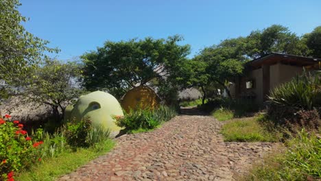 cobblestone path leading to eco-friendly dome homes in lush natural setting