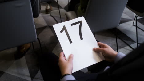 Man-holding-board-with-number-17