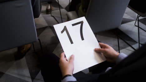 man holding board with number 17