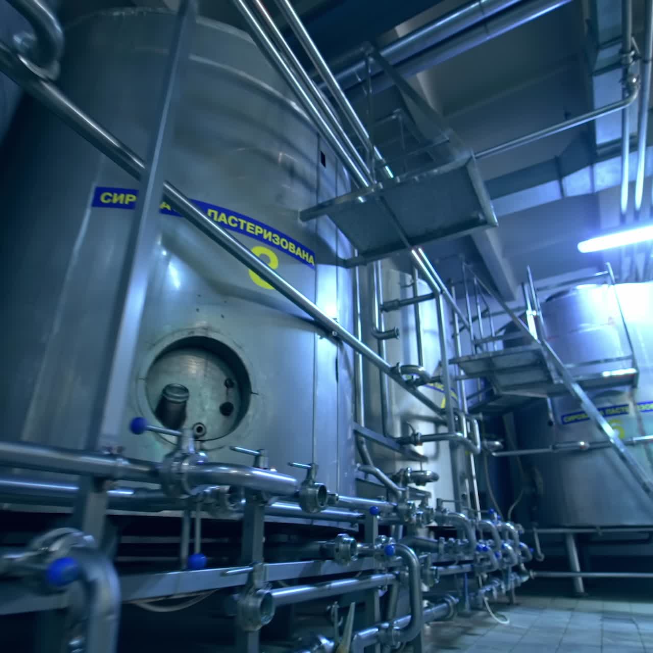 Large factory premises with tans and pipe systems. Facilities for dairy products enterprise. Dolly shot