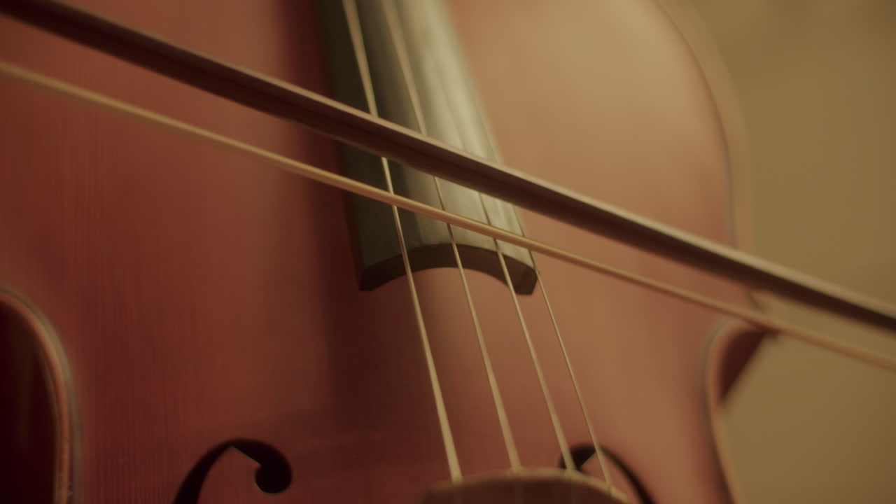 Handheld parallax shot shot of playing the cello with a bow