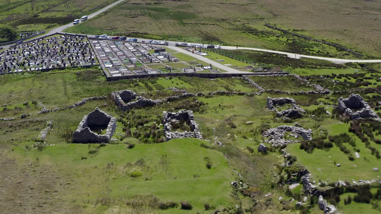 aerial overview of desereted village at slievemore and cemetery by green hills