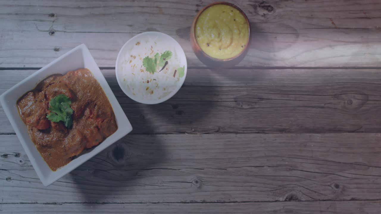 Lens flare appearing at right edge sweeping across three food bowls casting glow on rustic tabletop