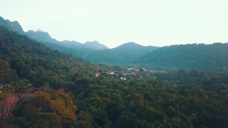 foto reveladora de un pueblo en medio de una selva tropical con las montañas al fondo, langkawi, malasia