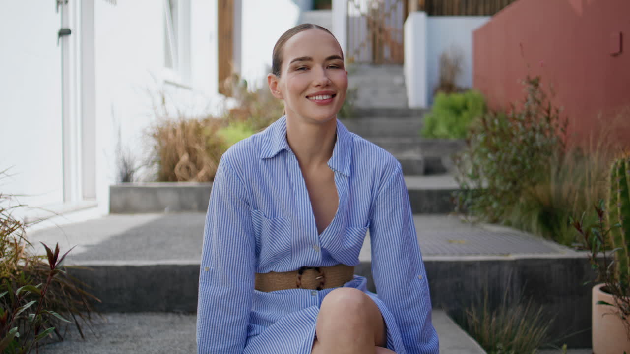 Elegant woman posing staircase looking camera closeup. Model girl crossing legs