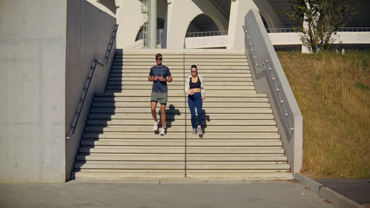 Couple Jogging Down Stairs at Stadium