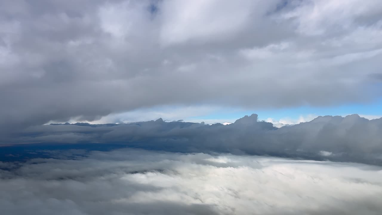 an immersive pilot’s eye view of a dreamy cloudscape captured from a jet cockpit while flying between layers of stratus clouds in a blue sky