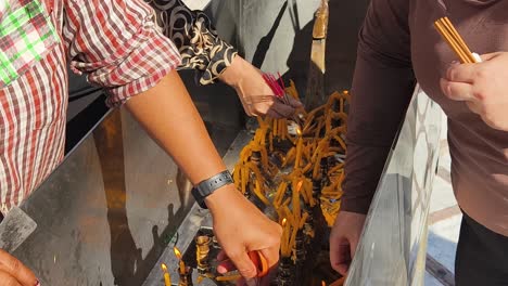 people praying at a temple with candles and incense