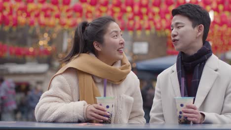 young asian couple on holiday drinking bubble tea in chinatown london uk 1