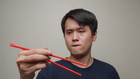 가락 초상화: 동남아시아 젊은이가 중국 음식 가리로 놀고 남자 모델 얼굴 스튜디오 촬영