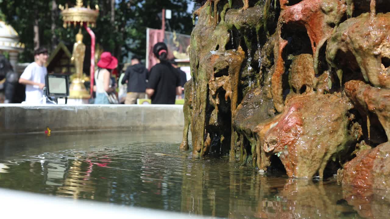 사람들이 지켜보는 동안 바위 에서 물이 흐르고 있습니다.