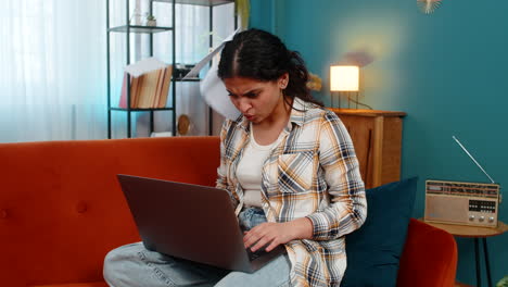 nervous woman reading laptop screen aggressively throwing receipts emotional breakdown stressed