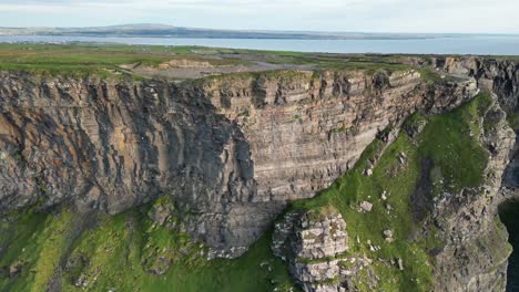 drone shot flying closer to the cliffs of moher at sunset