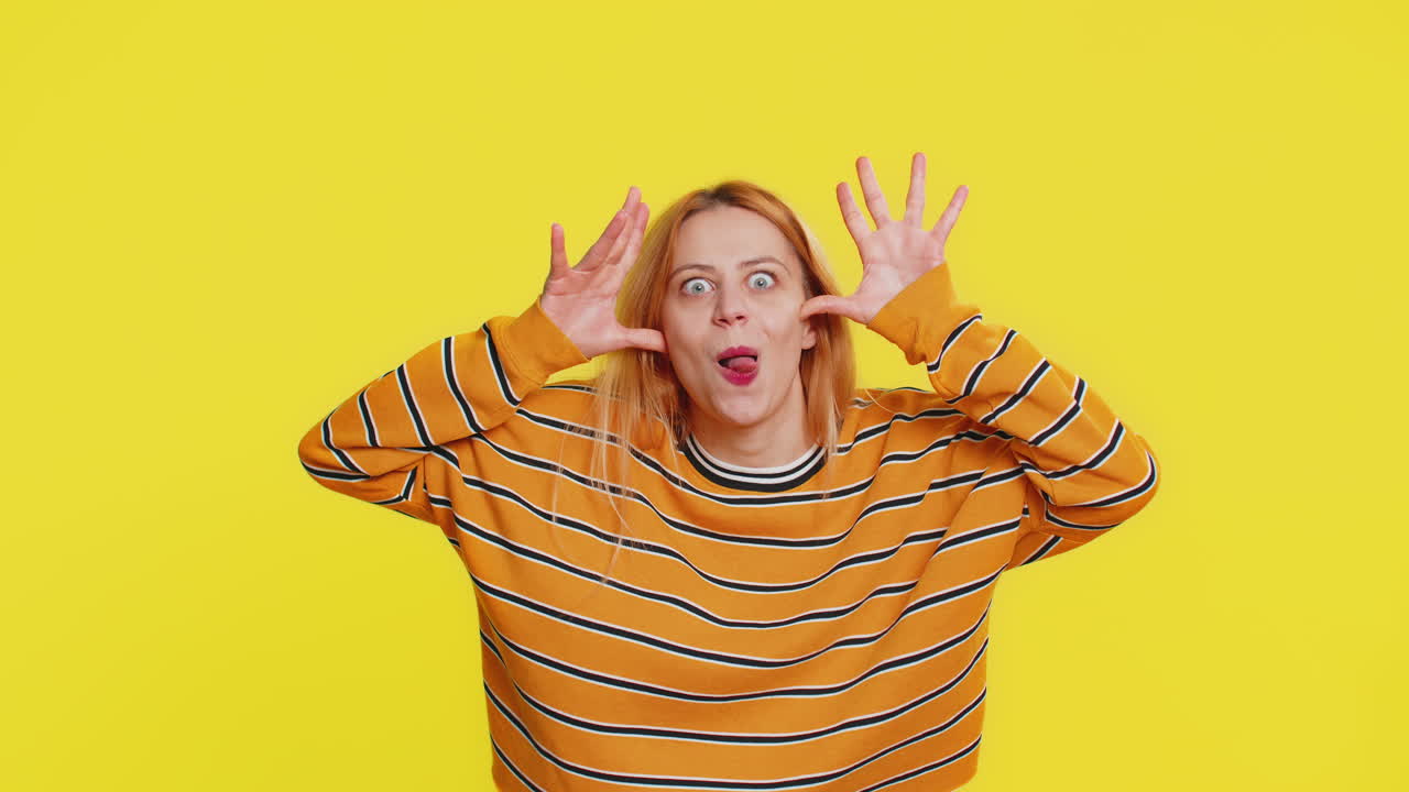 Cheerful funny bully woman showing tongue making silly faces fooling around joking teasing