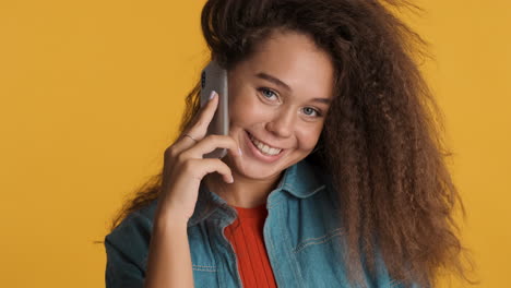 caucasian curly haired woman calling on smartphone.