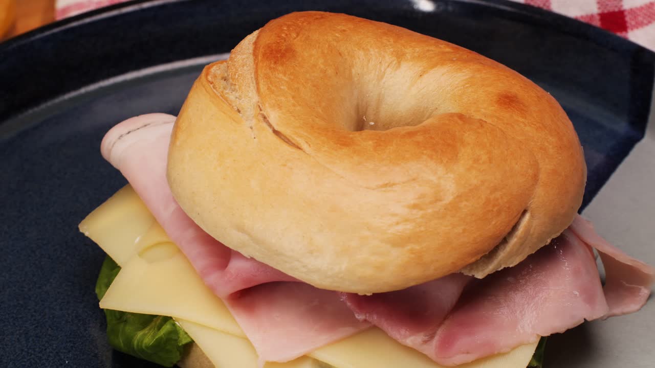 Bagel sandwich brunch, lunch plate of a bagel with smoked salmon and cream cheese and ham, close up morning cafe menu.